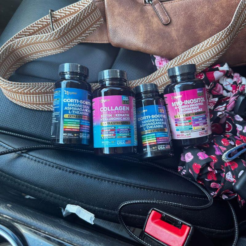 Bottles of dietary supplements on a car seat with a bag and seatbelt.