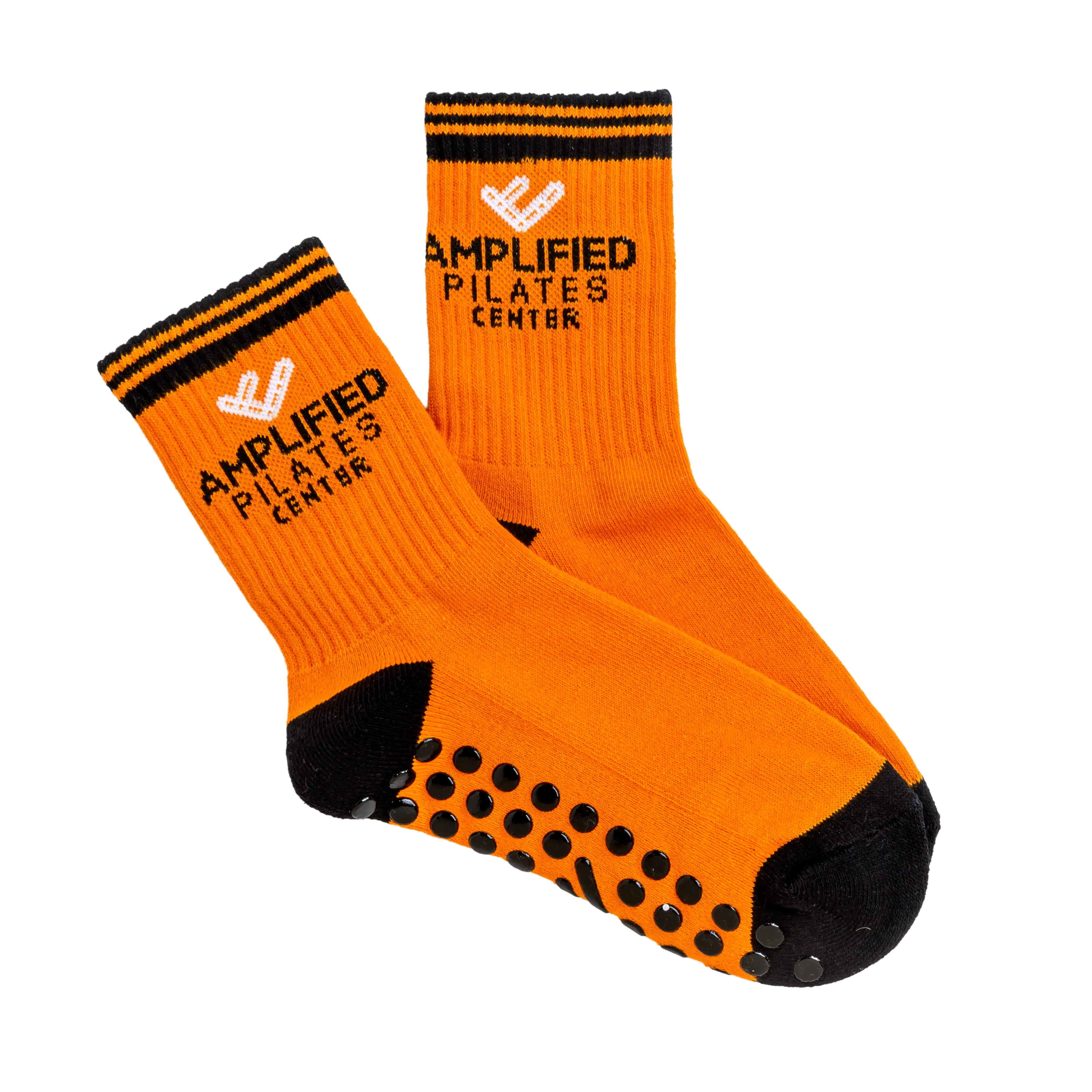 A pair of orange and black grip socks with the Amplified Pilates Center logo on the cuff.