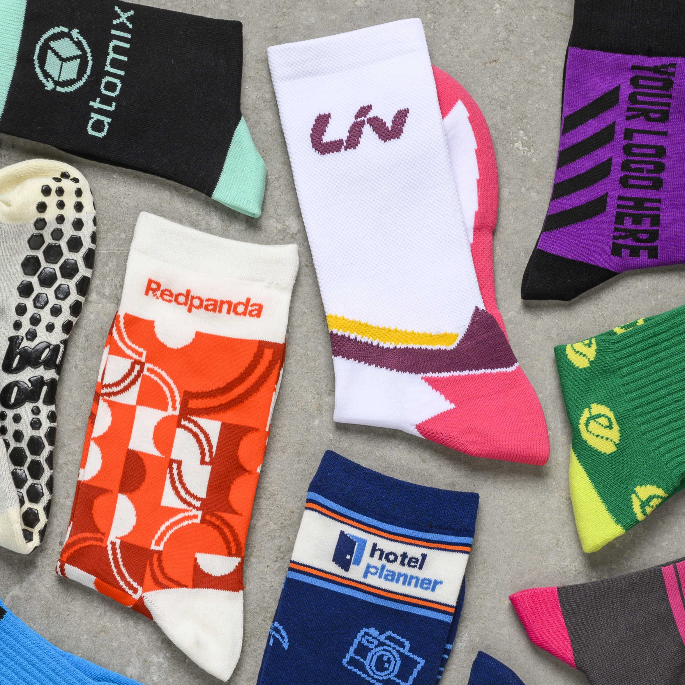 Multiple pairs of custom branded socks arranged together with vibrant logos and athletic styles.