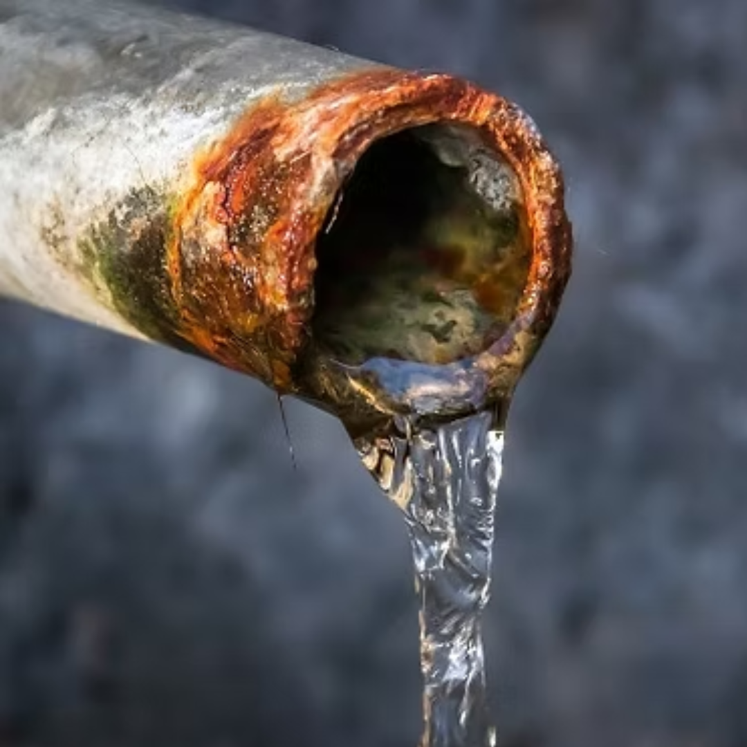 Rusty pipe with water flowing out.