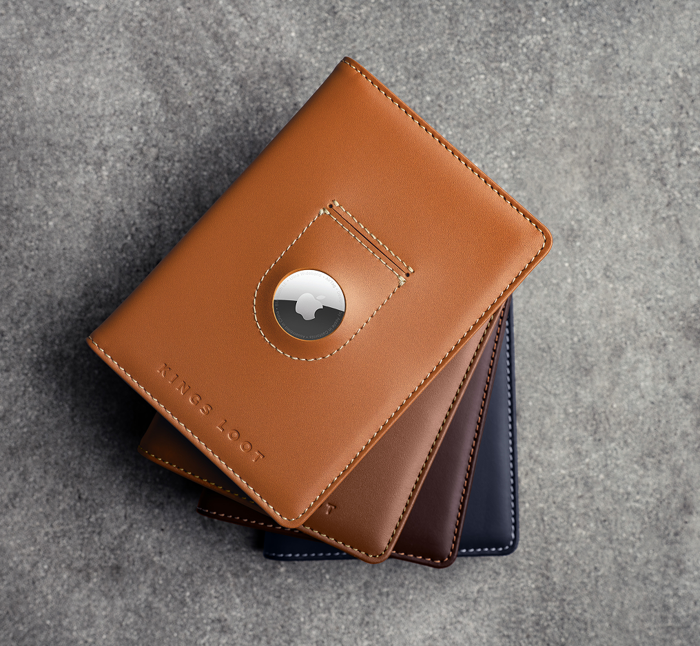 A stack of three leather wallets in tan, brown, and blue, with an Apple AirTag in the top one.