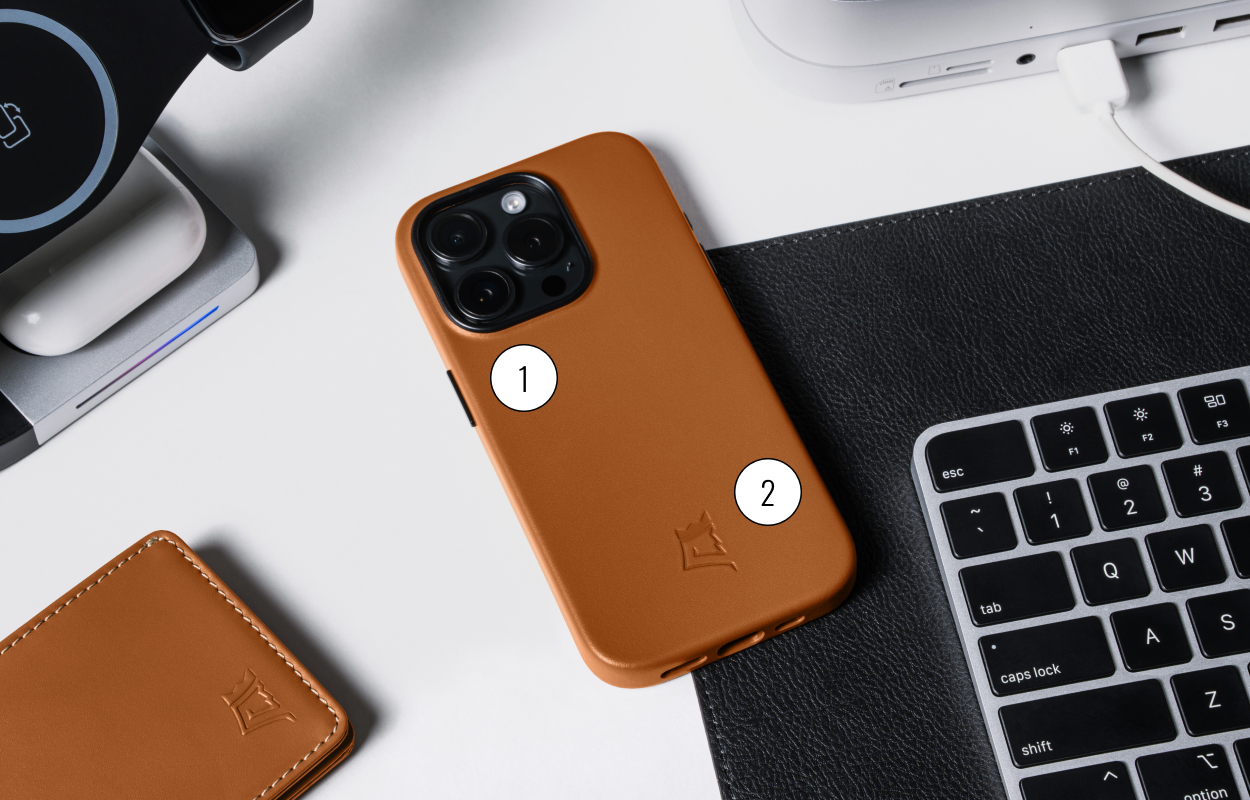 Brown phone case on desk with keyboard and charging station.