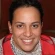 A person smiling at the camera, wearing a red jacket.