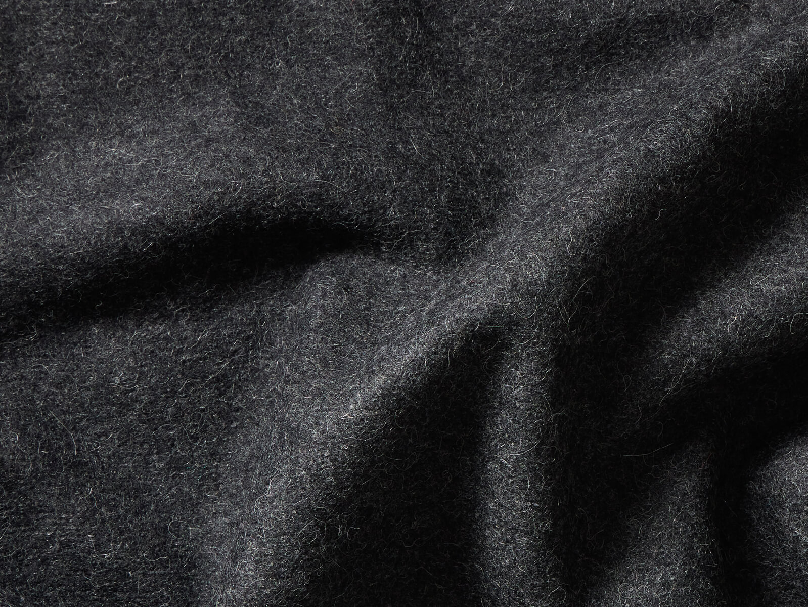Close-up of dark gray wool fabric with visible texture.