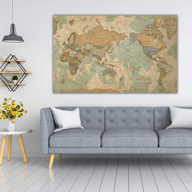 Living room with a gray sofa, world map on wall, and yellow flowers on table.