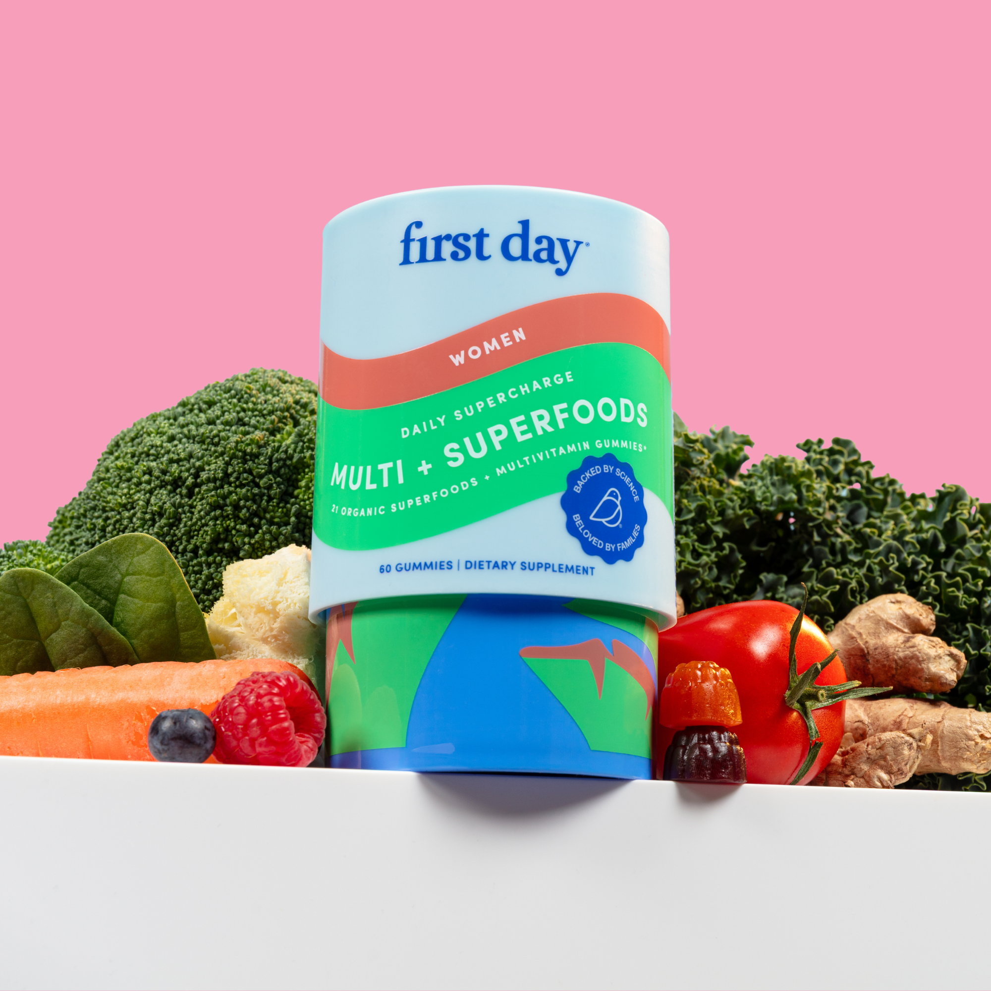 Supplement bottle with vegetables and fruits on a pink background.
