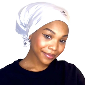 Person wearing a white headscarf and black shirt, smiling against a white background.