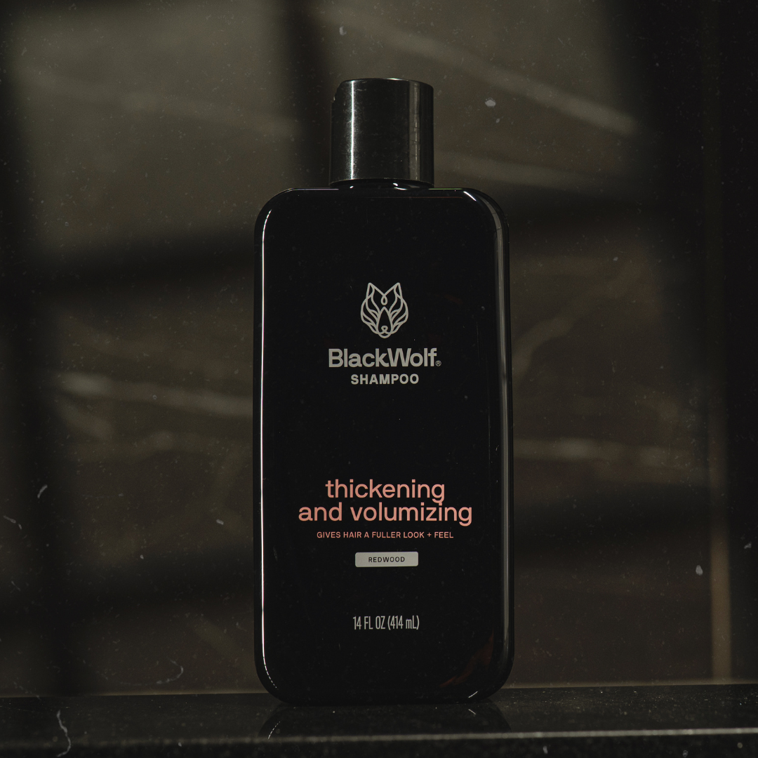 Black bottle of BlackWolf thickening and volumizing shampoo on a dark background.