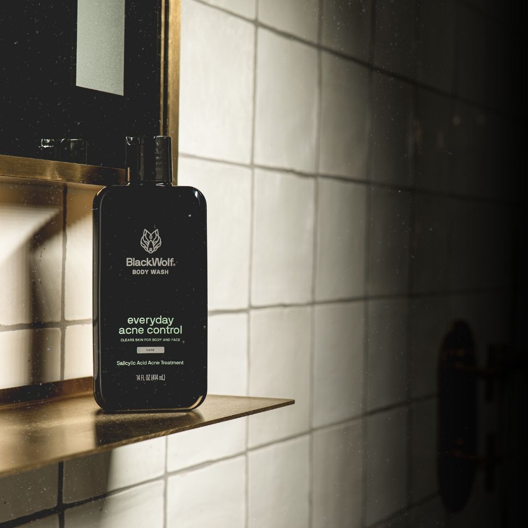 BlackWolf body wash bottle on a shelf against tiled wall.