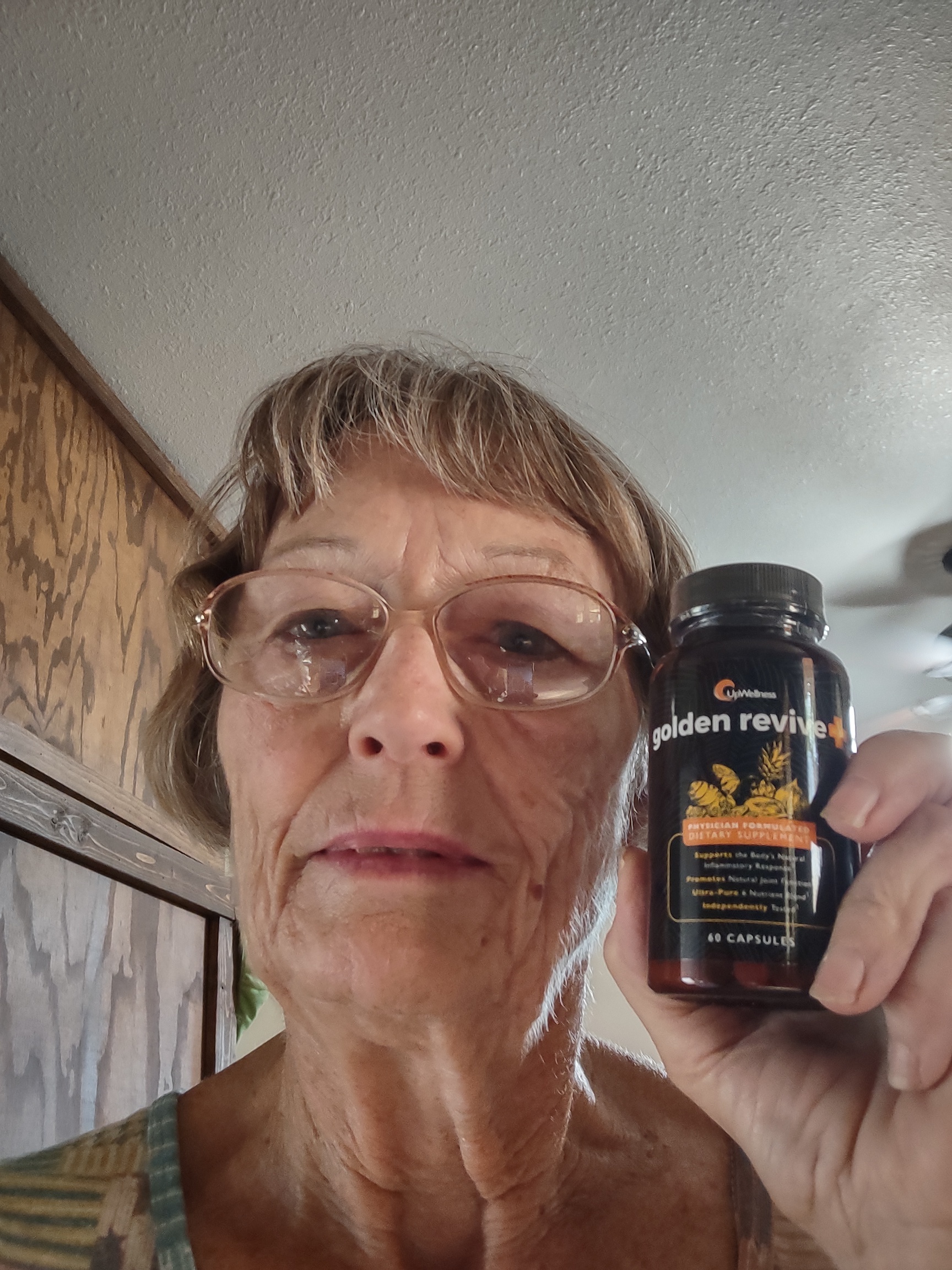 Large plant in a blue pot next to a wooden table with water jugs.