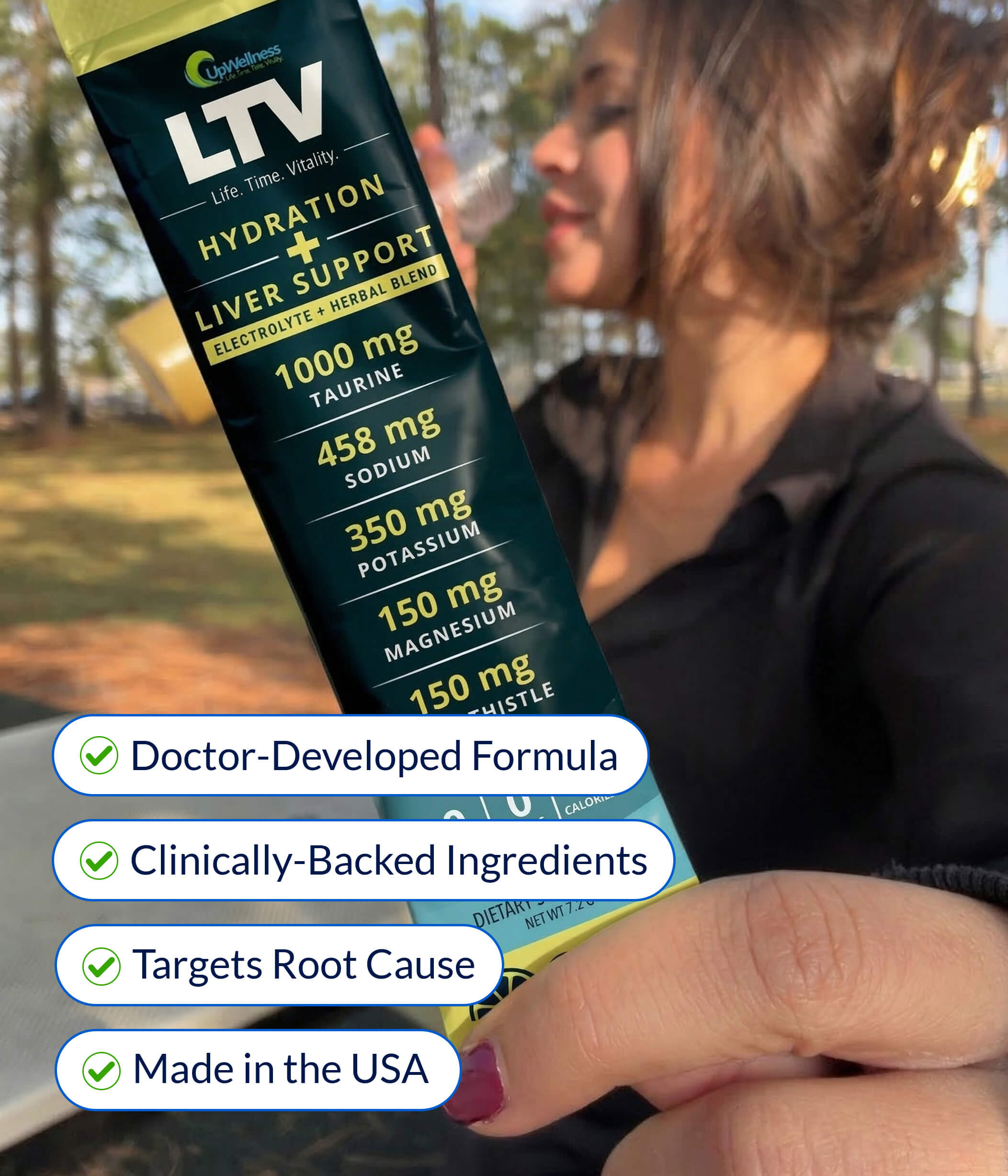 A close-up of an LTV Hydration + Liver Support supplement packet with a woman blurred in the background.