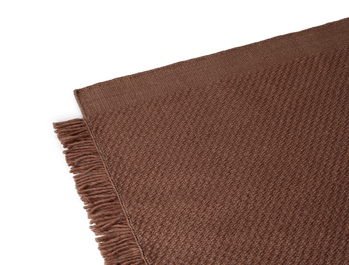 Brown woven rug with fringe on one edge.