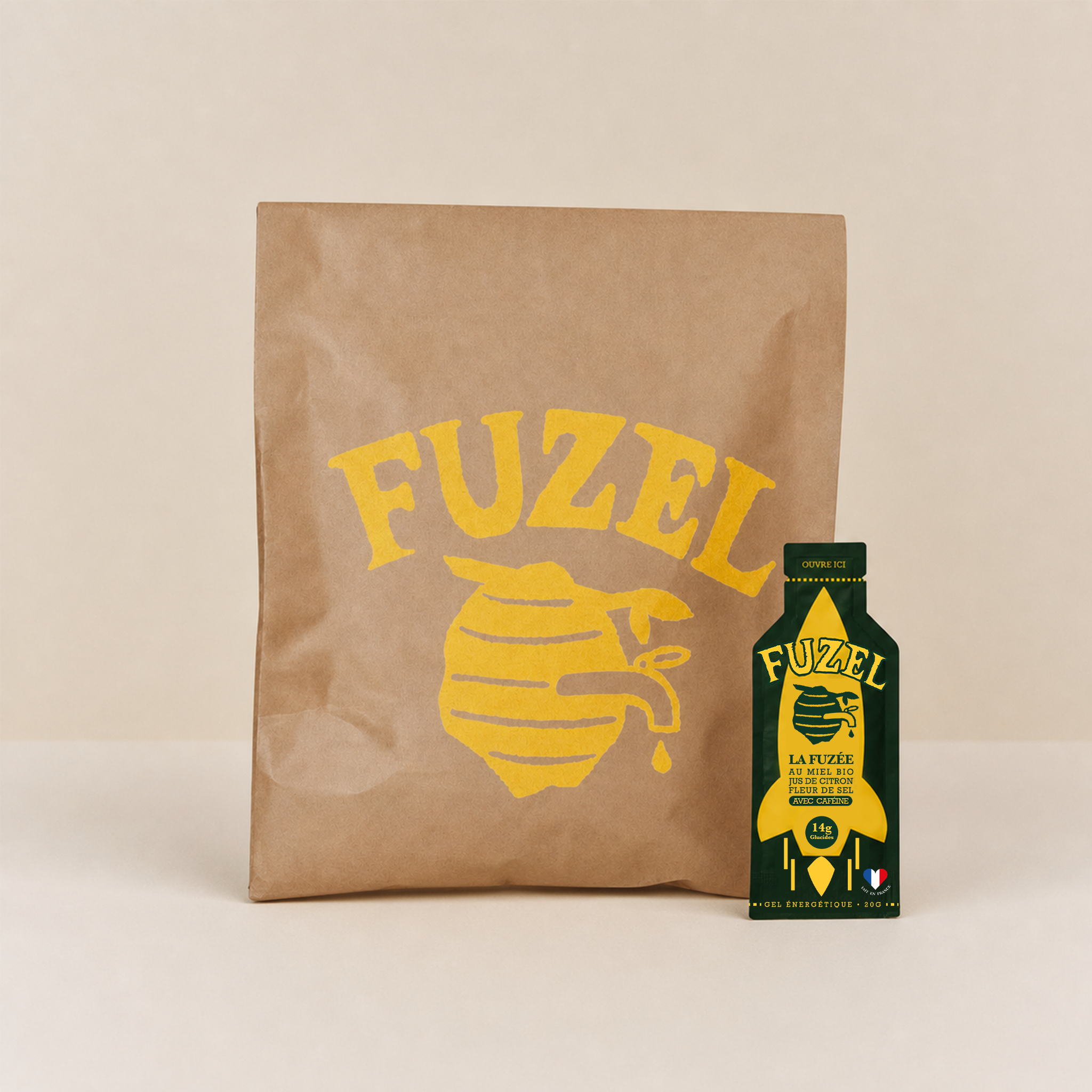 A Fuzel brand energy gel packet standing in front of a matching branded paper bag.