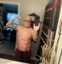 Man taking a shirtless mirror selfie in a bathroom.