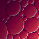 An abstract macro image of overlapping circular shapes in shades of red and purple.