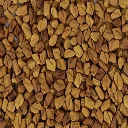 A close-up photograph of a pile of small, angular, light-brown fenugreek seeds.
