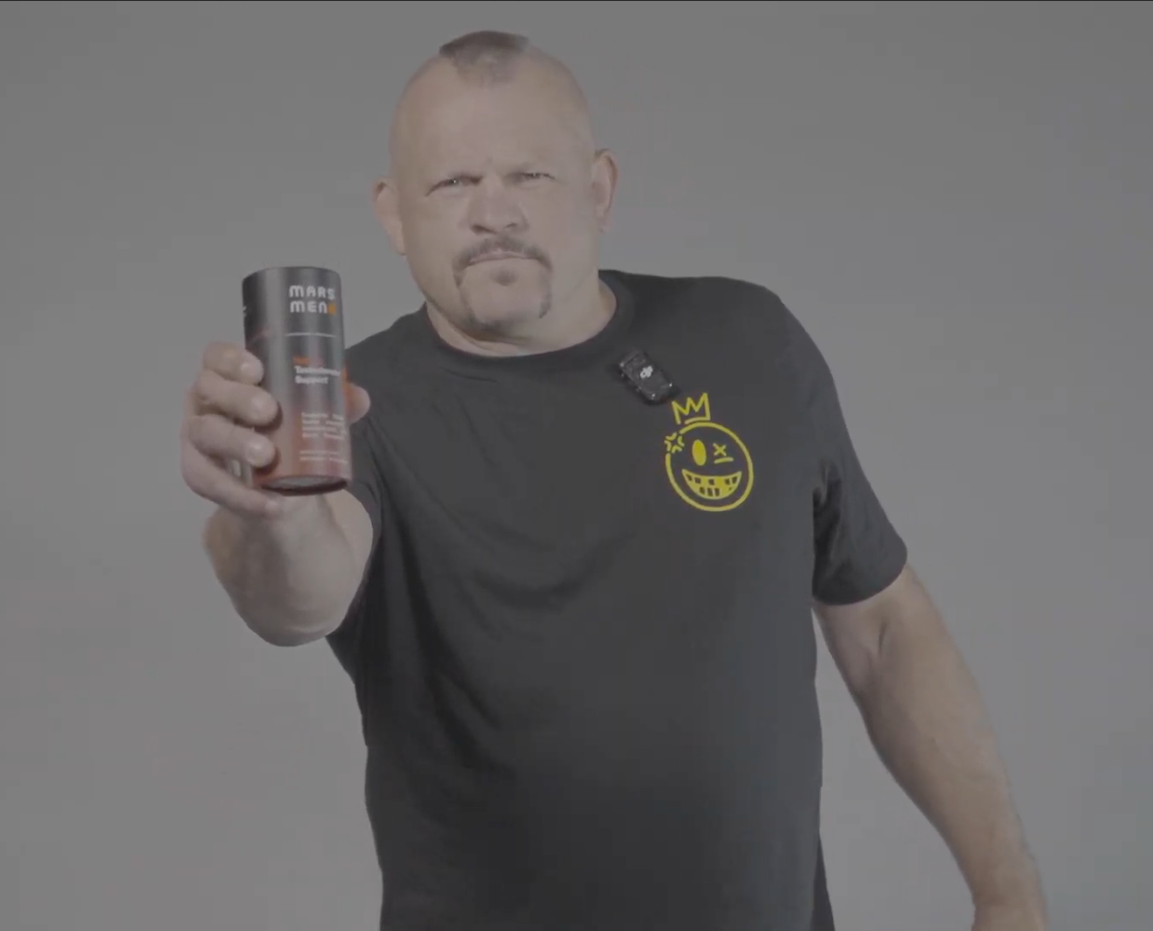 Person holding a Mars Men product, wearing a black shirt with a yellow smiley face.