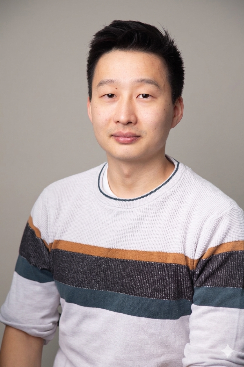 A headshot of an East Asian man with short black hair wearing a striped sweater against a gray background.