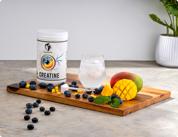 Creatine container, glass of water, mango, blueberries on a wooden board.