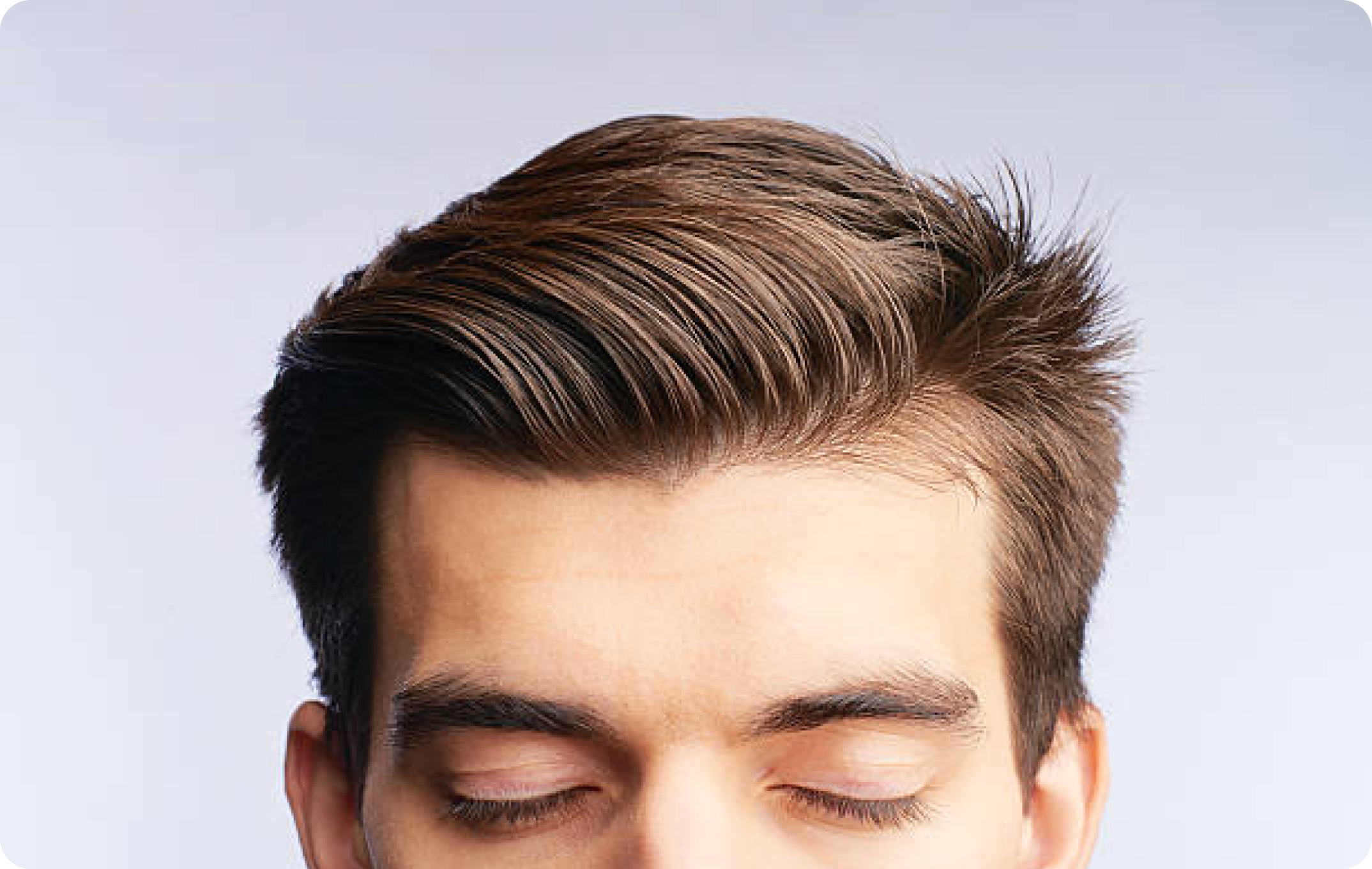Person with well-styled, brown hair and eyes closed.