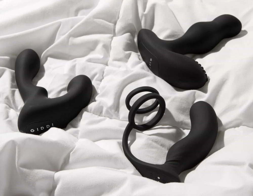 Three black silicone Prostate Massager Giddy on white fabric.