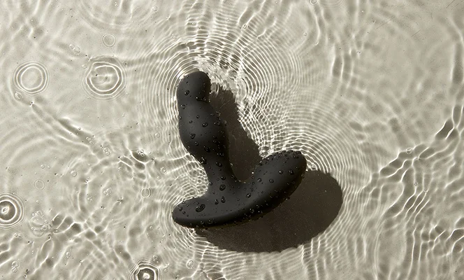 Prostate Massager Giddy Thor with water droplets on rippling water surface