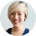 A blurry, circular headshot of a smiling person with short blonde hair.