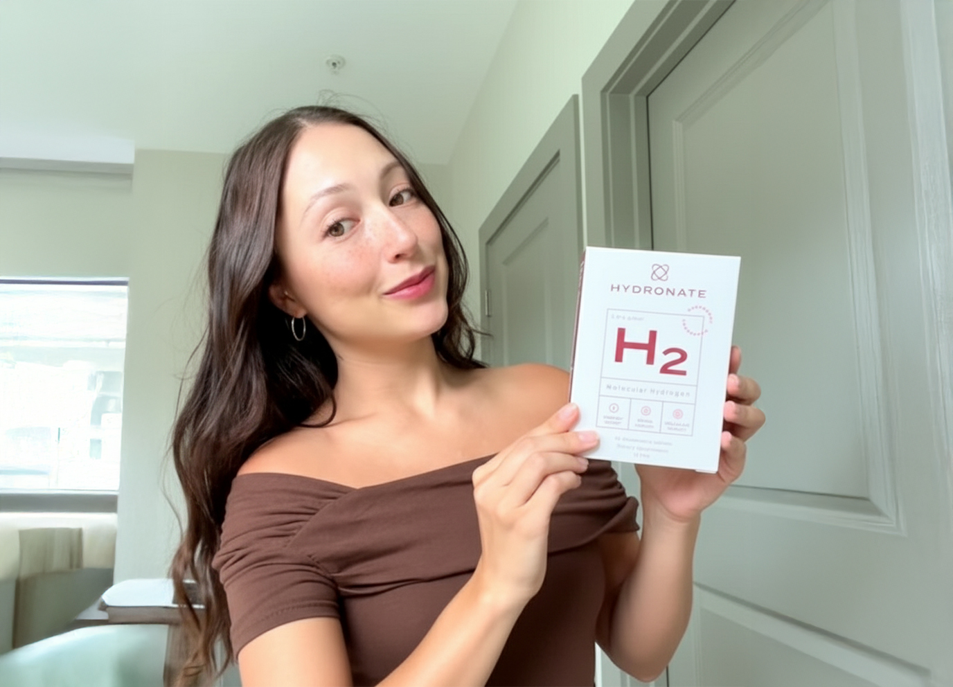 Person holding a Hydronate H2 product box indoors.
