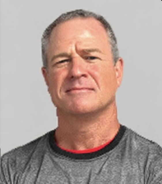 A person wearing a grey shirt is looking forward against a plain background.