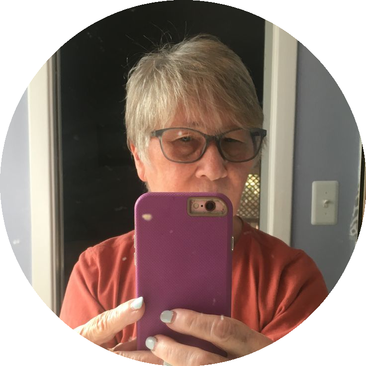 Person taking a selfie in a mirror with a purple phone case.