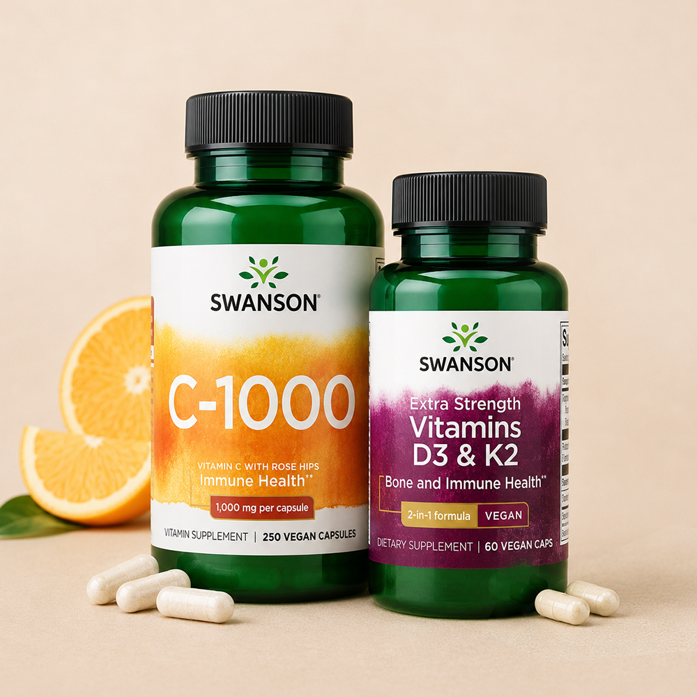 Two Swanson vitamin bottles, C-1000 and Extra Strength Vitamins D3 & K2, displayed with orange slices and white capsules.
