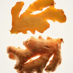 Sliced ginger root with vibrant yellow and brown tones on a white background.