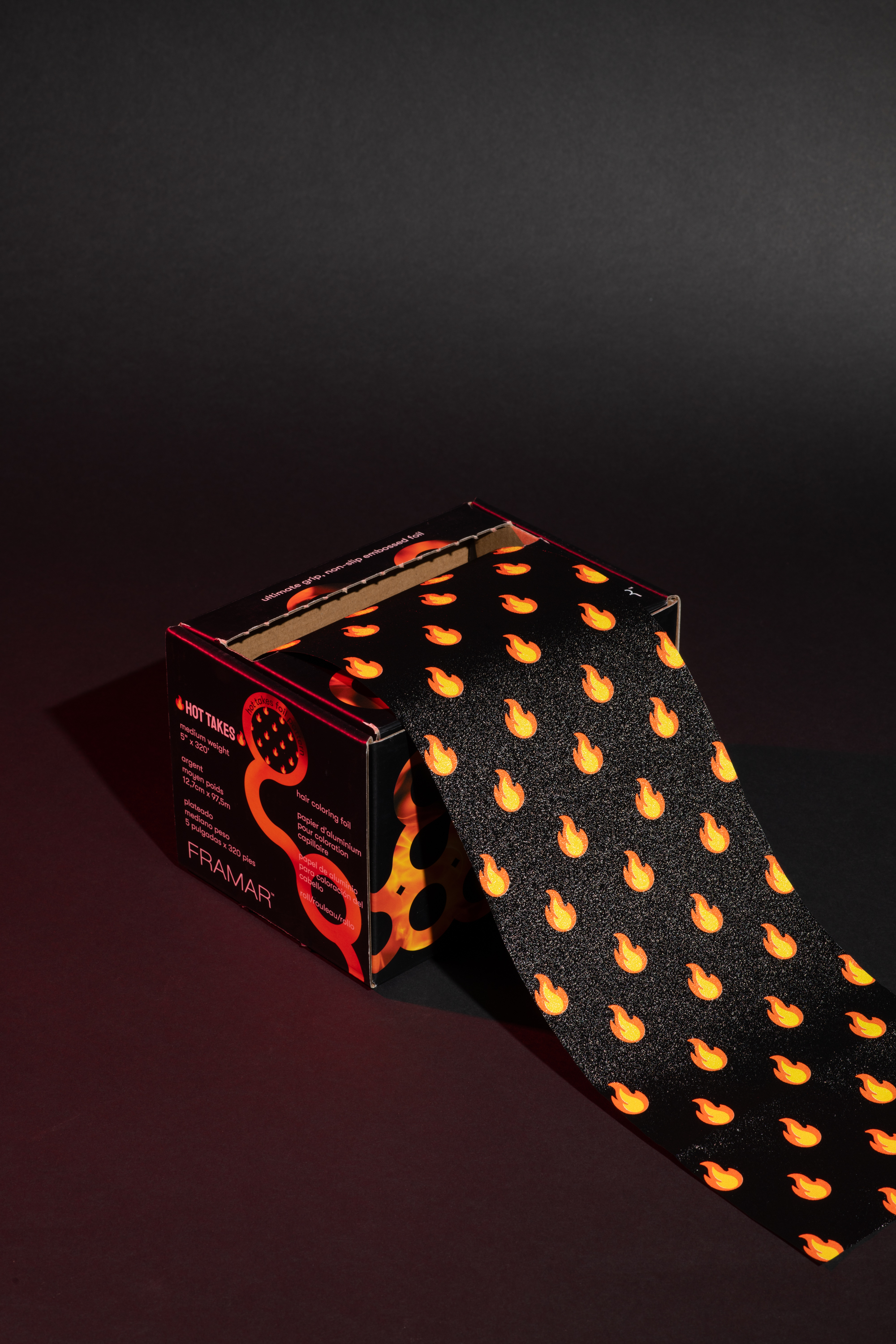 Box of foil with flame pattern on black background.