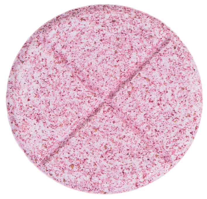 A close-up of a round, pink speckled tablet with a cross scored on its surface.