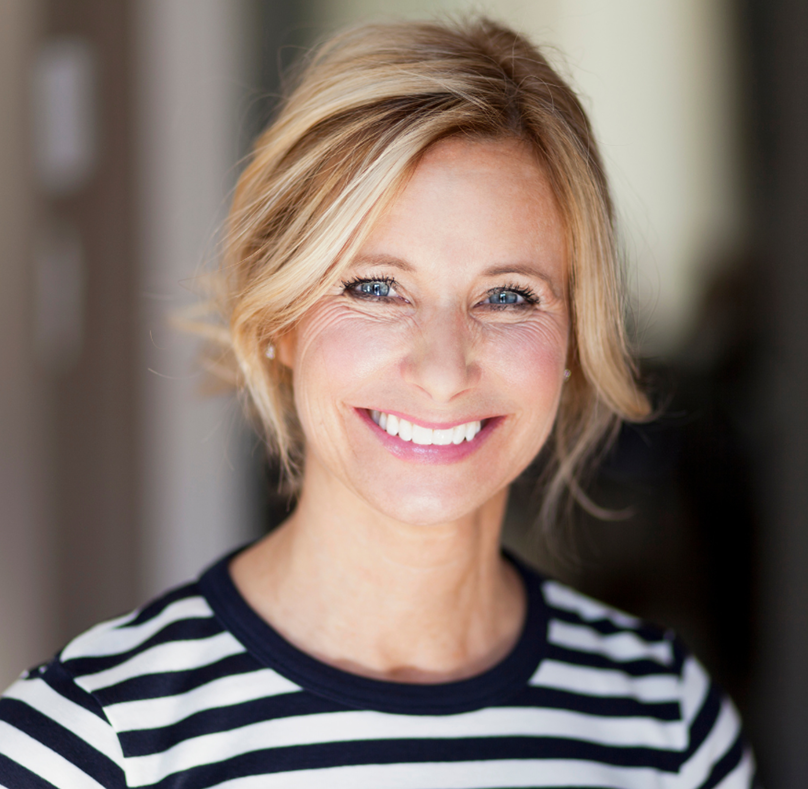A person smiling in a striped shirt.