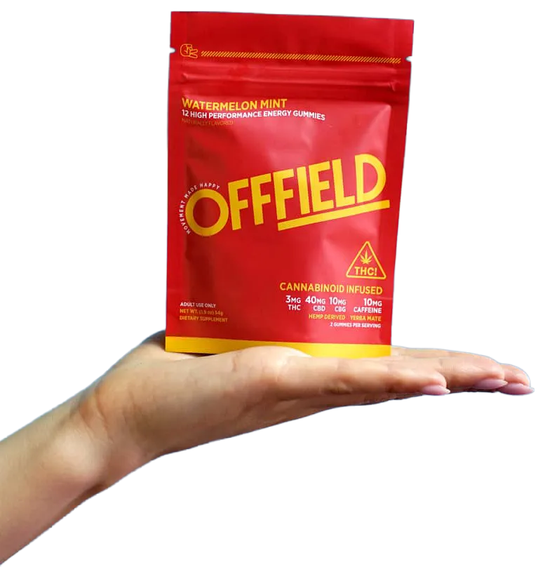 A hand holds a red pouch of OFFFIELD Watermelon Mint energy gummies against a white background.