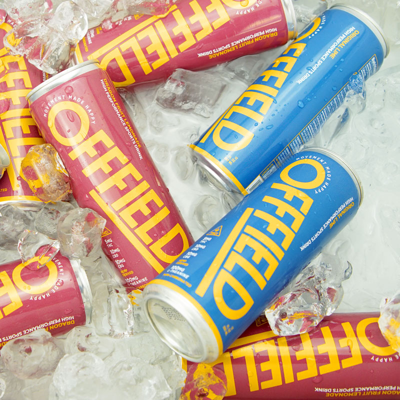 Cans of OFFFIELD sports drink in ice, red and blue packaging.