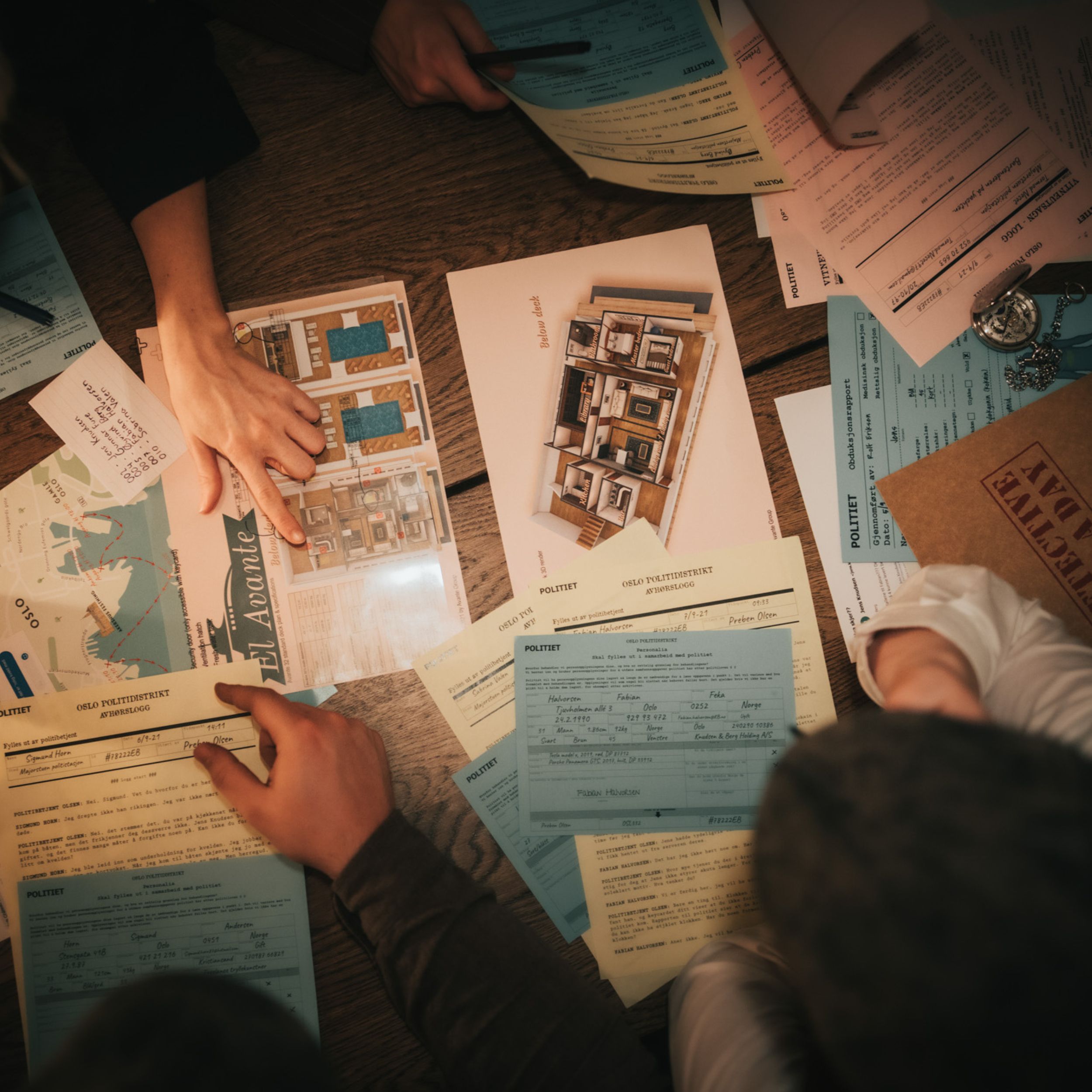 People examining documents and maps on a wooden table.