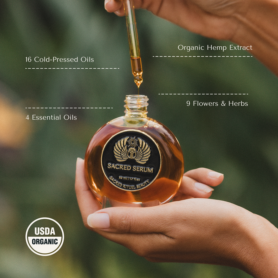 Hands holding a bottle of Sacred Serum with a dropper.