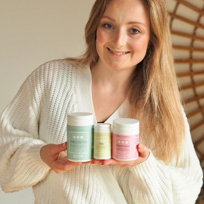 Smiling woman holding health supplement containers.