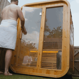 Person in towel entering a wooden outdoor sauna.