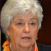 Person with short gray hair and wearing an orange scarf.