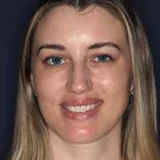 Portrait of a person with long hair smiling at the camera.
