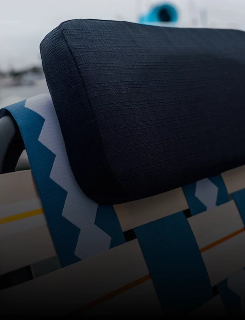 Close-up of a woven chair with a dark cushion.