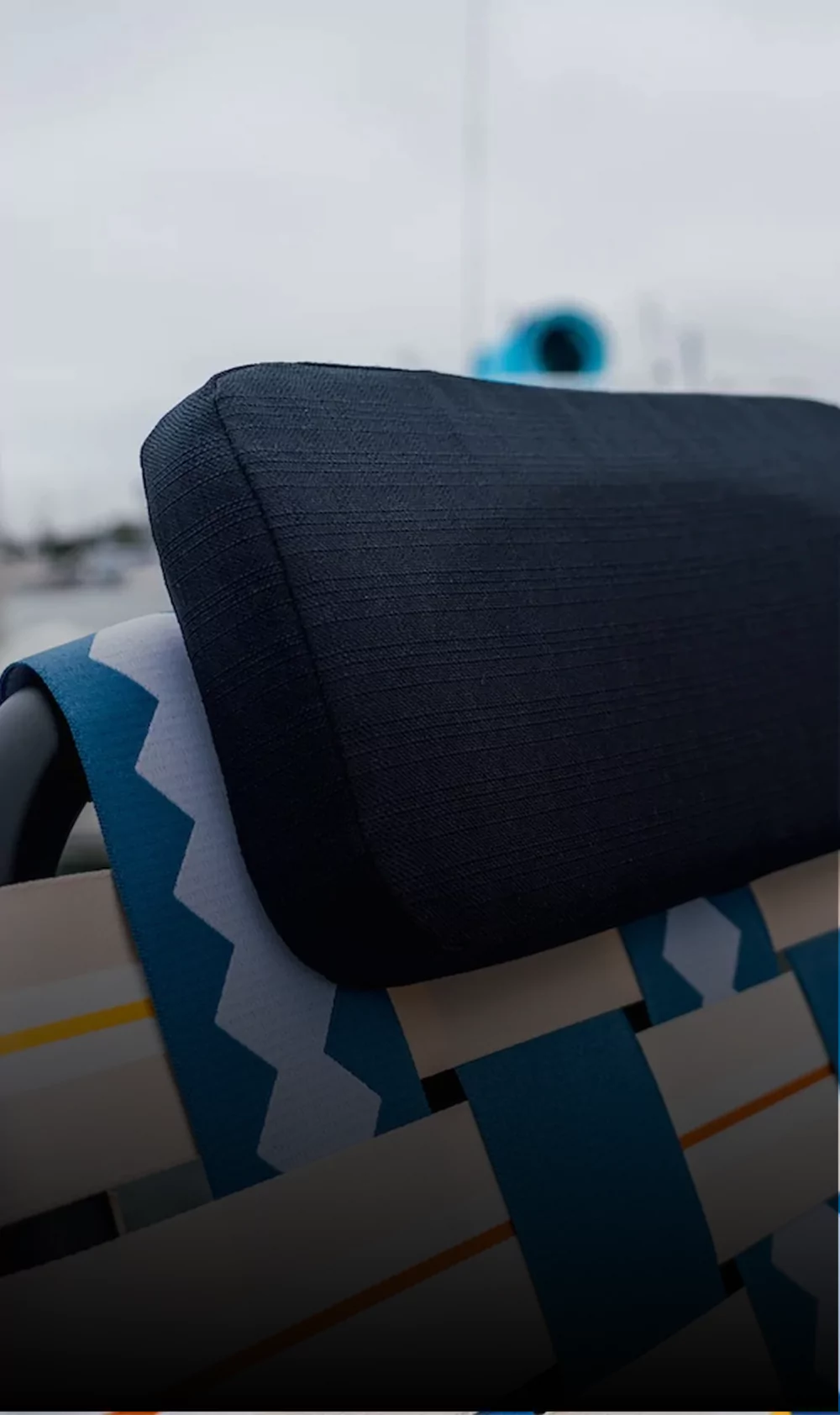 Close-up of a woven chair with a dark cushion.