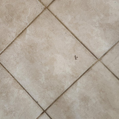Close-up of beige tiled floor with visible grout lines.