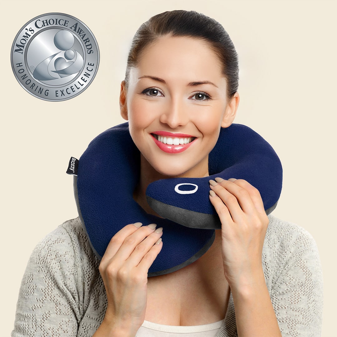 Smiling woman with a blue neck pillow and award logo on the side.