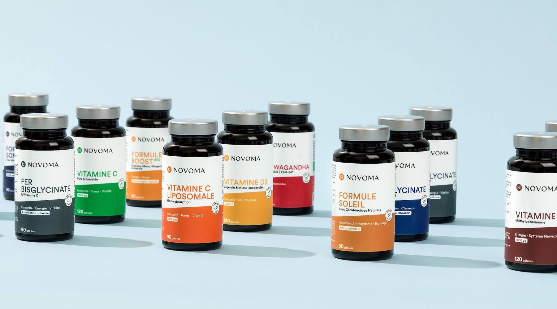 Various Novoma supplement bottles arranged on a light blue background.