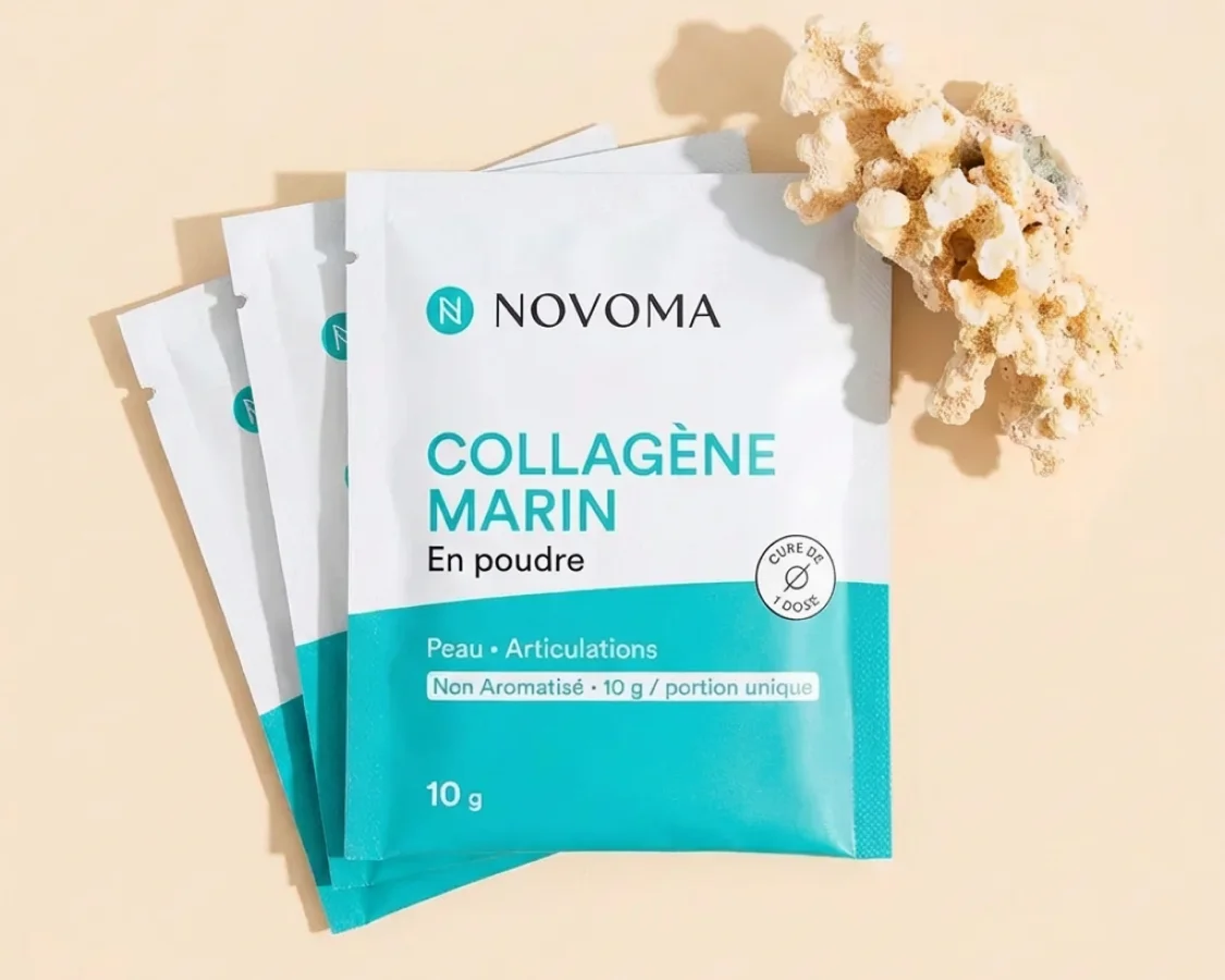 Three single-serving packets of Novoma Marine Collagen powder next to a piece of coral on a flat surface.