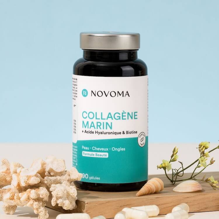 Bottle of marine collagen supplement with coral and seashells nearby.